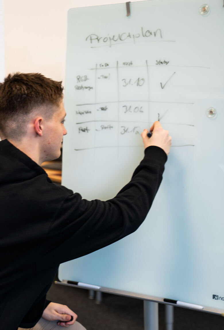 Young man writes on a writing board